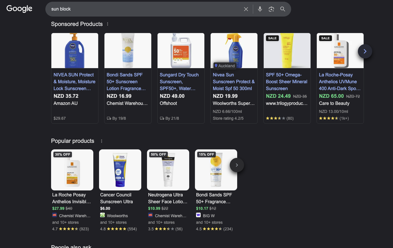 Google search results for sun block with a Sponsored Products ad carousel at the top and the organic Popular products grid below it, showing discount badges, prices, retailer names and pooled review counts